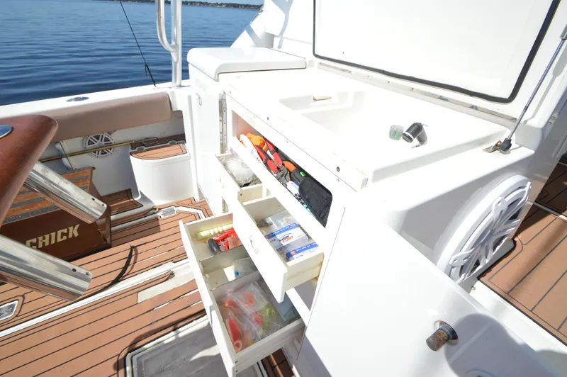Side Chick Yacht Photos Pics 2002 Rampage 38 Express boat interior with open storage drawers and fishing gear.