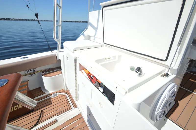 Side Chick Yacht Photos Pics 2002 Rampage 38 Express boat interior with sink and storage, overlooking calm waters.