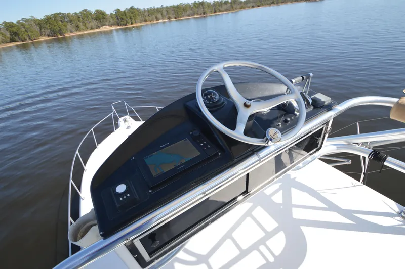 Side Chick Yacht Photos Pics Helm of 2002 Rampage 38 Express boat with steering wheel and navigation system.