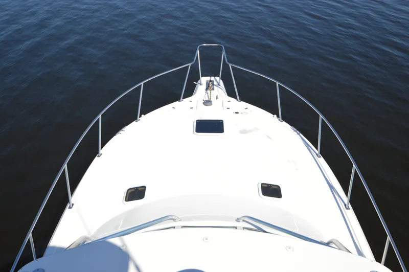 Side Chick Yacht Photos Pics Bow view of 2002 Rampage 38 Express boat on calm water.