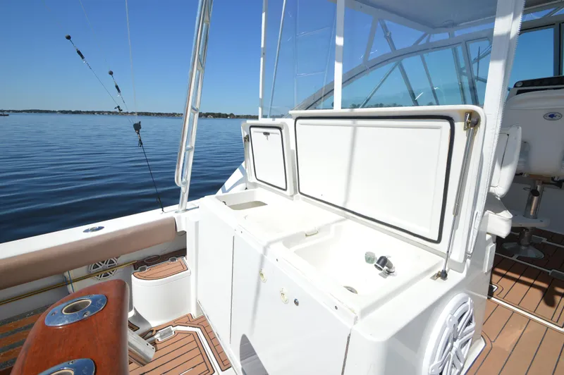 Side Chick Yacht Photos Pics 2002 Rampage 38 Express boat deck with fishing equipment and storage compartments.