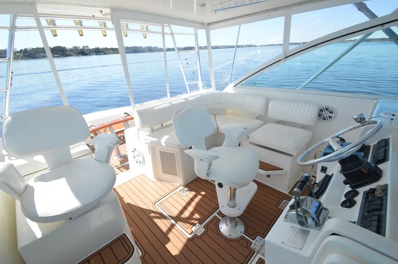 Side Chick Yacht Photos Pics 2002 Rampage 38 Express yacht interior with white seating and wooden flooring, overlooking calm waters.