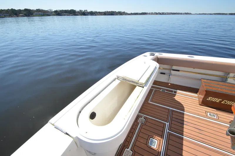 Side Chick Yacht Photos Pics 2002 Rampage 38 Express boat deck with open storage, on calm water.