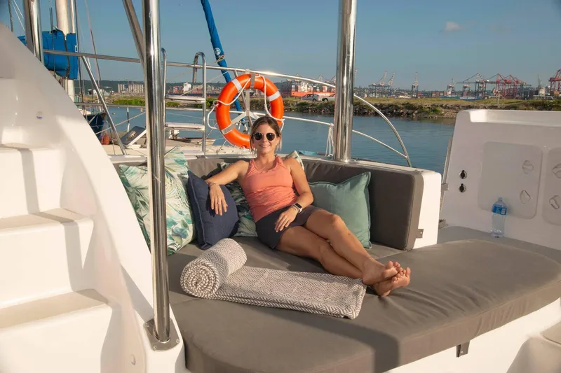 Barefeet Retreat Yacht Photos Pics Woman relaxing on Royal Cape Catamarans Majestic 570 yacht, 2020 model, with scenic harbor view.