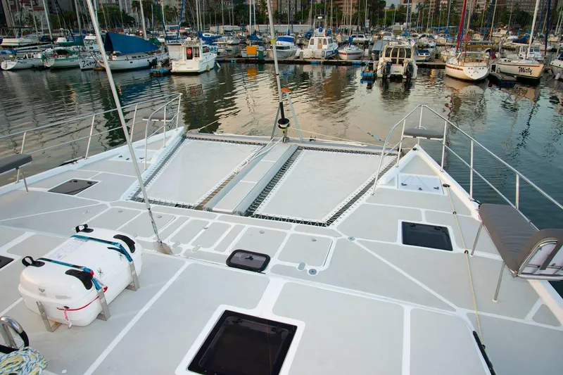 Barefeet Retreat Yacht Photos Pics 2020 Royal Cape Catamarans Majestic 570 docked in a marina, showcasing spacious deck and netting.