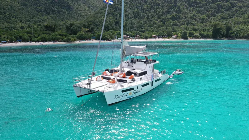 Barefeet Retreat Yacht Photos Pics 2020 Royal Cape Catamarans Majestic 570 sailing in clear turquoise waters near lush coastline.