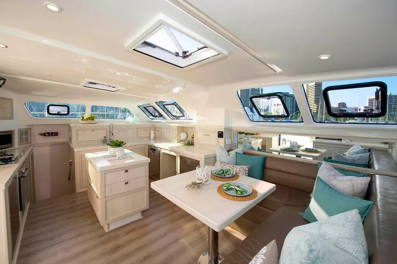 Barefeet Retreat Yacht Photos Pics Luxurious interior of 2020 Royal Cape Catamarans Majestic 570 with modern kitchen and dining area.