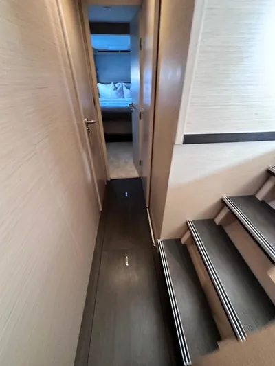  Yacht Photos Pics Interior hallway of 2021 Lagoon 50 yacht, featuring modern design and wooden stairs.
