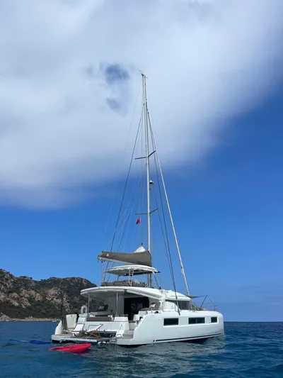  Yacht Photos Pics 2021 Lagoon 50 catamaran sailing on clear blue waters under a partly cloudy sky.