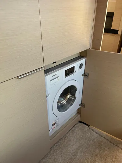  Yacht Photos Pics Built-in washing machine in Lagoon 50 yacht, 2021 model, with wooden cabinetry.