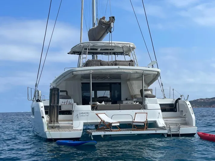  Yacht Photos Pics 2021 Lagoon 50 catamaran on water, rear view with clear sky background.