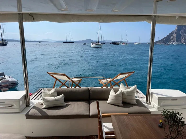  Yacht Photos Pics Luxurious Lagoon 50 yacht deck with seating, ocean view, and sailboats in the distance.