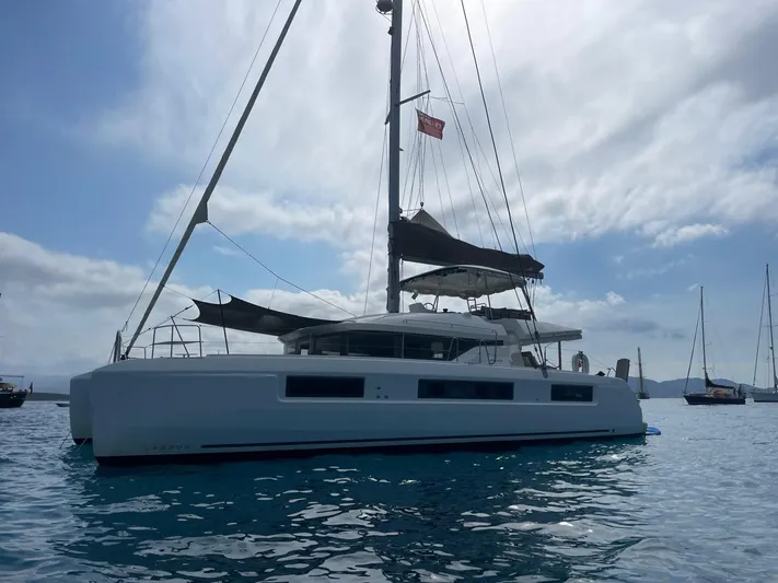  Yacht Photos Pics 2021 Lagoon 50 catamaran sailing on calm waters under a cloudy sky.