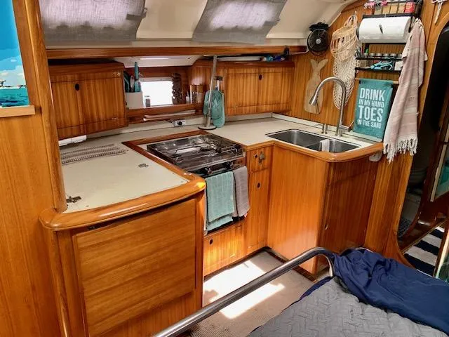 Mockingbird Yacht Photos Pics Interior of 2001 Dufour Gib'Sea 43 yacht kitchen with wooden cabinetry and modern amenities.