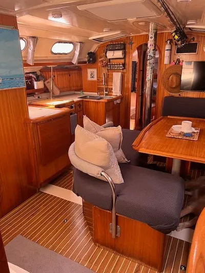 Mockingbird Yacht Photos Pics Interior of 2001 Dufour Gib'Sea 43 sailboat with wooden furnishings and cozy seating area.
