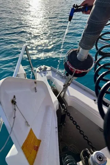 Mockingbird Yacht Photos Pics Washing anchor chain on 2001 Dufour Gib'Sea 43 sailboat in clear blue water.