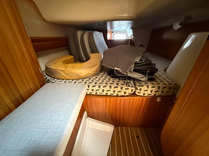 Mockingbird Yacht Photos Pics Cozy cabin interior of 2001 Dufour Gib'Sea 43 sailboat with cushions and wooden paneling.