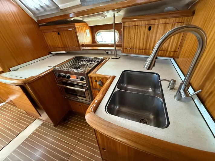 Mockingbird Yacht Photos Pics 2001 Dufour Gib'Sea 43 yacht kitchen with wooden cabinetry, dual sink, and stainless steel stove.