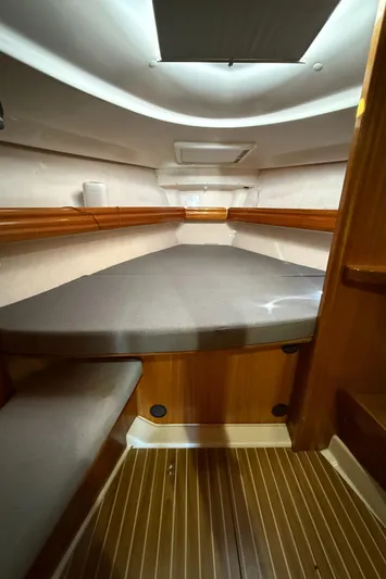 Mockingbird Yacht Photos Pics Cabin interior of 2001 Dufour Gib'Sea 43 sailboat with wooden finish and cushioned berth.