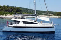 Luxury Privilege 515 yacht sailing near a scenic coastline, 2010 model.