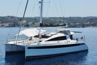 Luxury Privilege 515 catamaran from 2010 anchored in serene coastal waters.