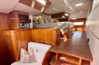 Luxurious interior of 2010 Privilege 515 yacht with wooden finishes and cozy bedding.