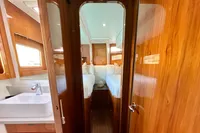Luxurious cabin interior of 2010 Privilege 515 yacht with wooden finish and cozy bedding.