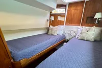 Luxurious twin cabin in 2010 Privilege 515 yacht with elegant bedding and wood paneling.