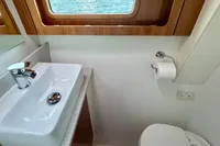 Compact yacht bathroom with sink, toilet, and window view on Privilege 515, 2010 model.