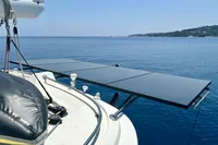Sailboat with solar panels on deck, Privilege 515, 2010 model, on calm blue sea.