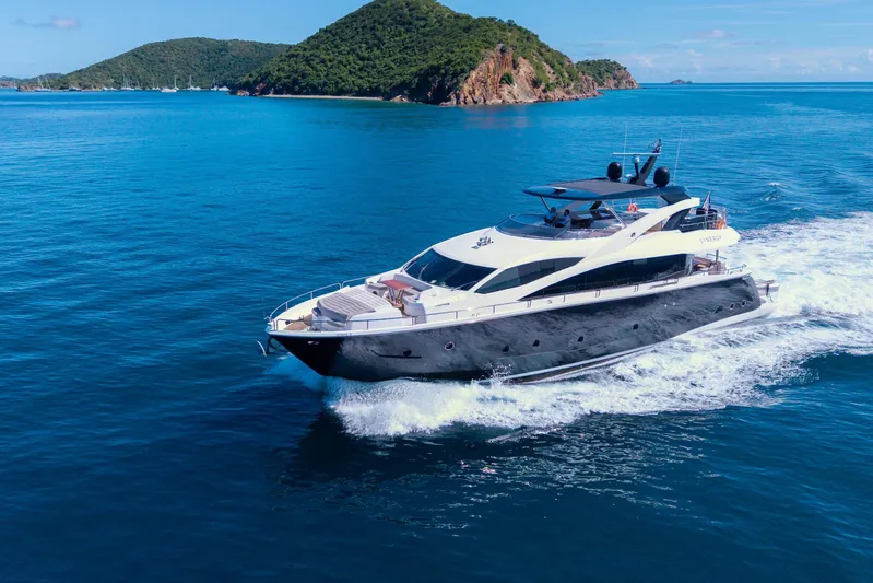  Yacht Photos Pics 2017 Sunseeker 86 Yacht cruising in clear blue waters near lush green islands.