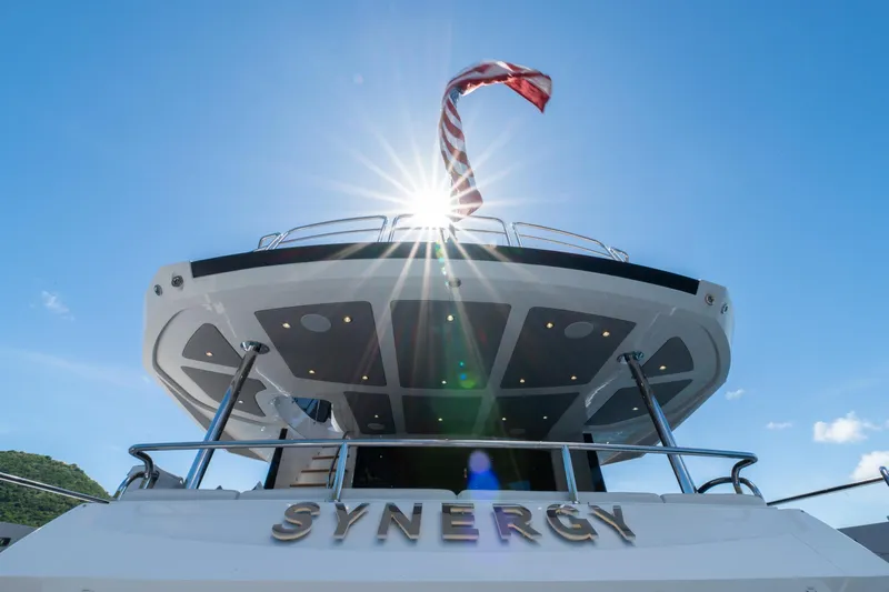  Yacht Photos Pics Sunseeker 86 Yacht 2017, rear view with sunburst and flag, named "Synergy".