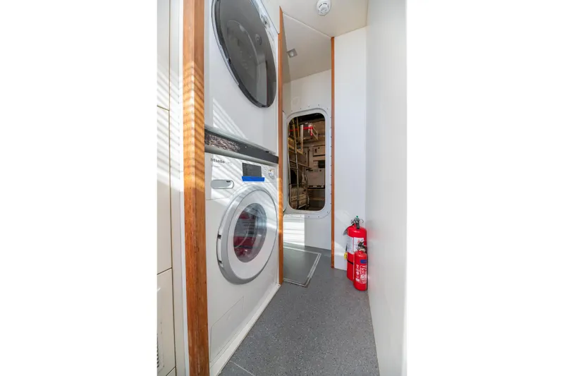  Yacht Photos Pics Laundry area on 2017 Sunseeker 86 Yacht with washer, dryer, and fire extinguisher.