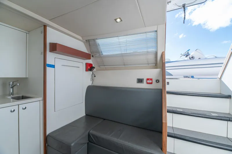  Yacht Photos Pics Interior of 2017 Sunseeker 86 Yacht with seating, stairs, and kitchenette.