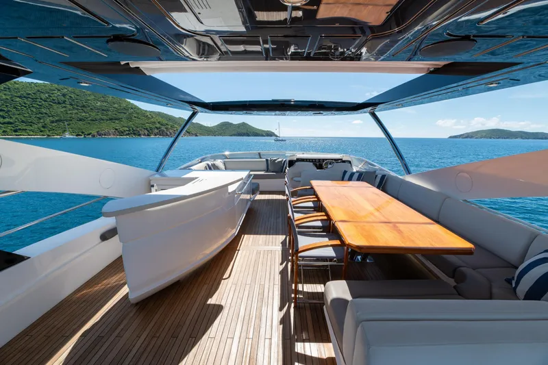  Yacht Photos Pics Luxurious 2017 Sunseeker 86 Yacht deck with dining area, overlooking serene ocean and lush islands.