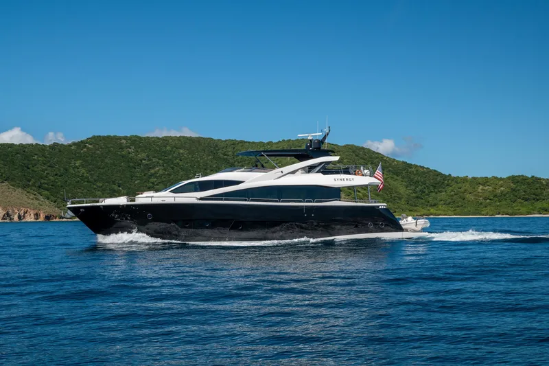  Yacht Photos Pics 2017 Sunseeker 86 Yacht cruising on blue waters near lush green hills.