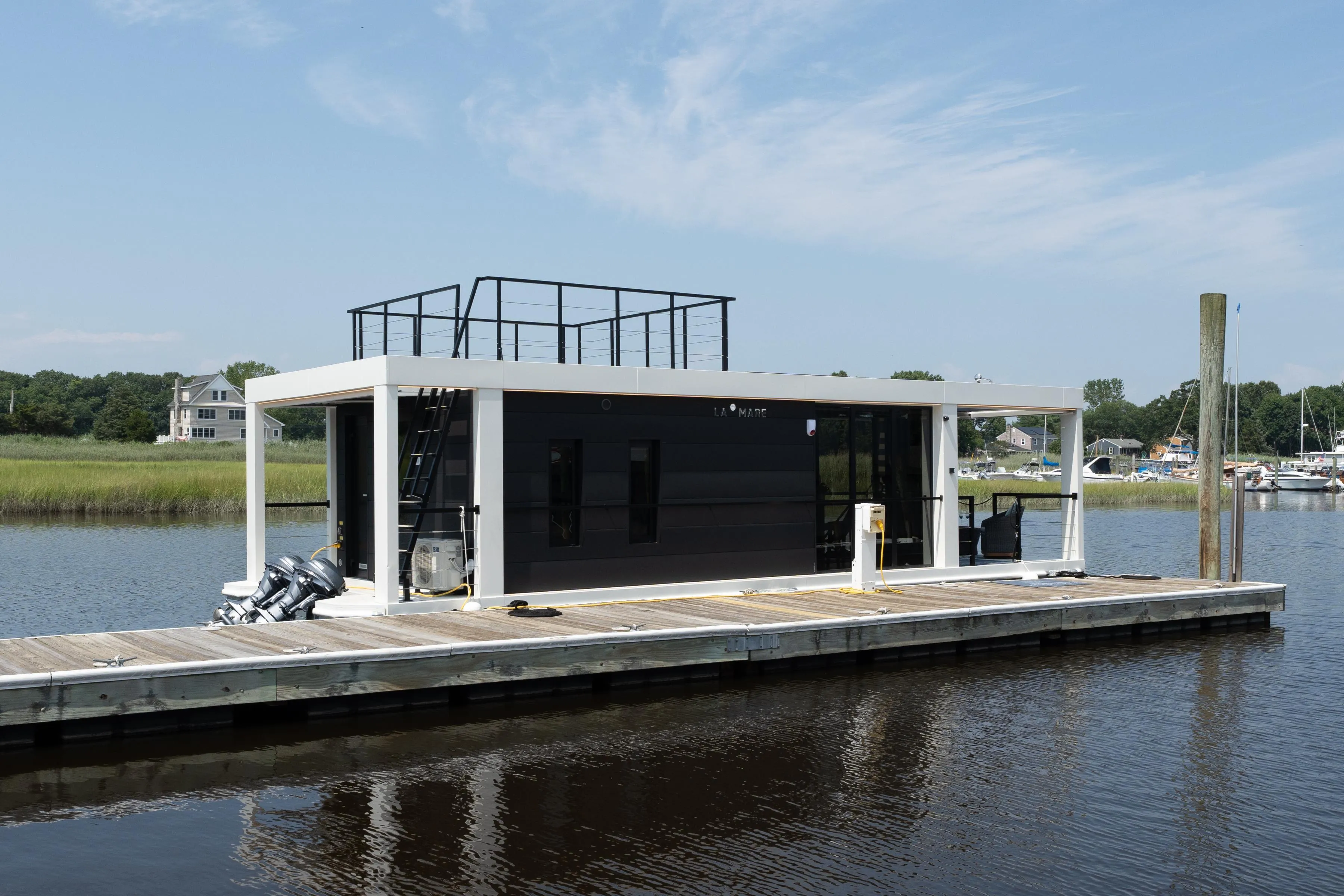 Modern Waterlodge 11 houseboat docked on a serene river, 2025 model.