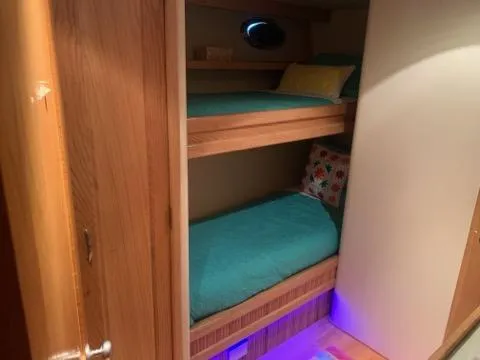 The Jobsite Yacht Photos Pics Bunk beds in 1988 Viking Motor Yacht cabin with teal bedding and ambient lighting.
