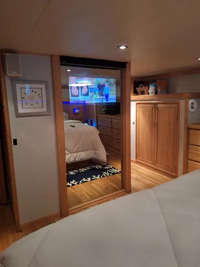 The Jobsite Yacht Photos Pics Interior of 1988 Viking Motor Yacht bedroom with wooden cabinets and cozy bedding.