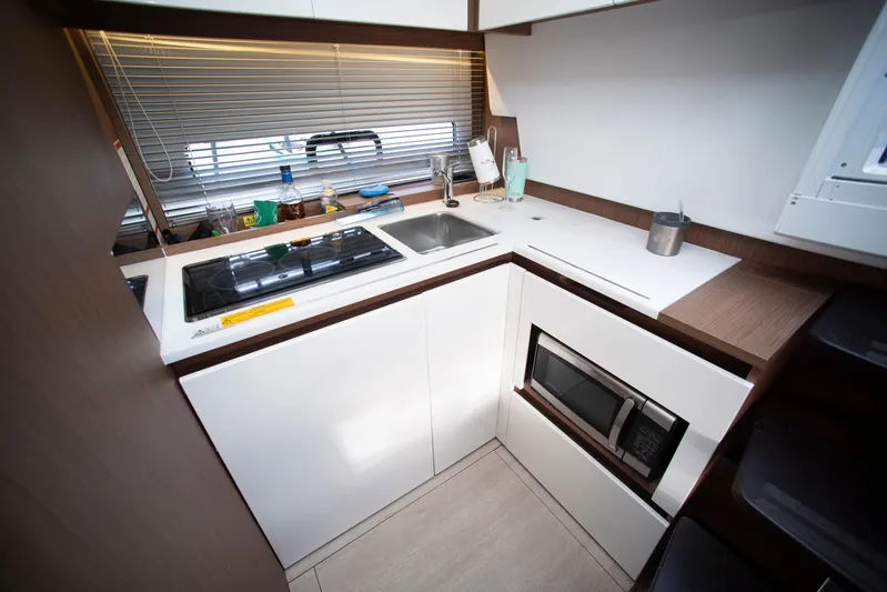 Chichochu Yacht Photos Pics Compact kitchen in a 2017 Jeanneau Leader 40 yacht, featuring modern appliances and sleek design.