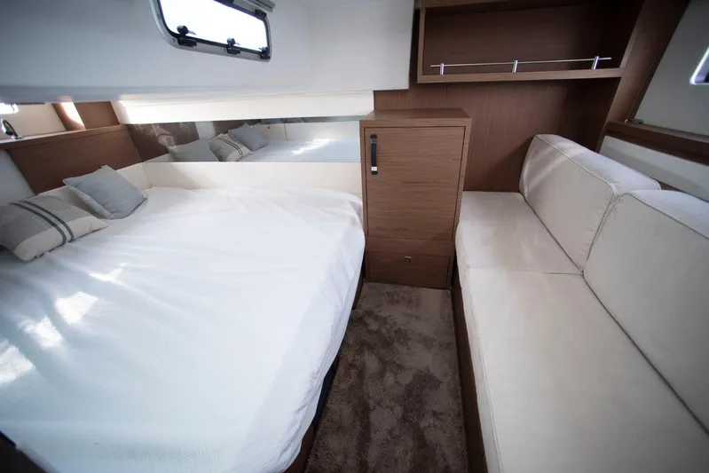Chichochu Yacht Photos Pics 2017 Jeanneau Leader 40 cabin interior with bed, sofa, and wooden cabinetry.