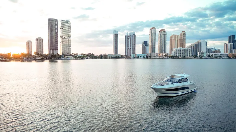Chichochu Yacht Photos Pics 2017 Jeanneau Leader 40 yacht cruising near city skyline at sunset.