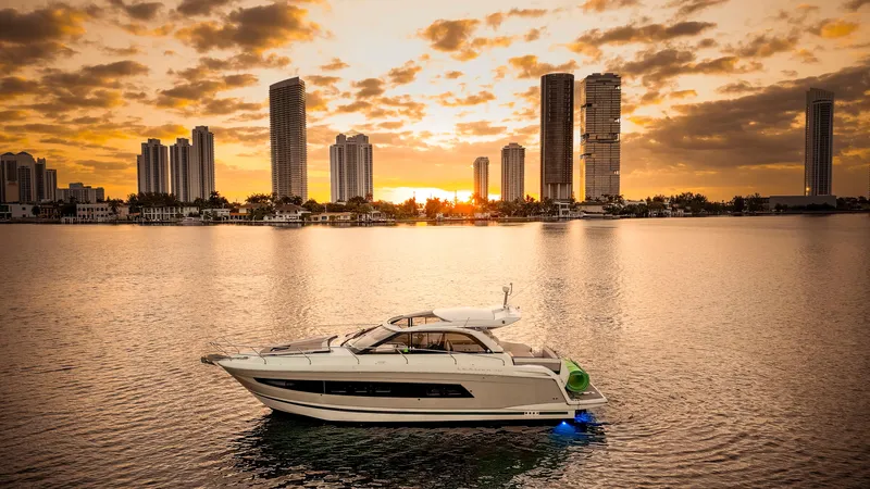 Chichochu Yacht Photos Pics Jeanneau Leader 40 yacht on water at sunset, city skyline in background, 2017 model.