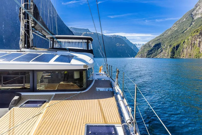  Yacht Photos Pics Lagoon 52 S yacht sailing through scenic fjord with clear blue skies, 2017 model.