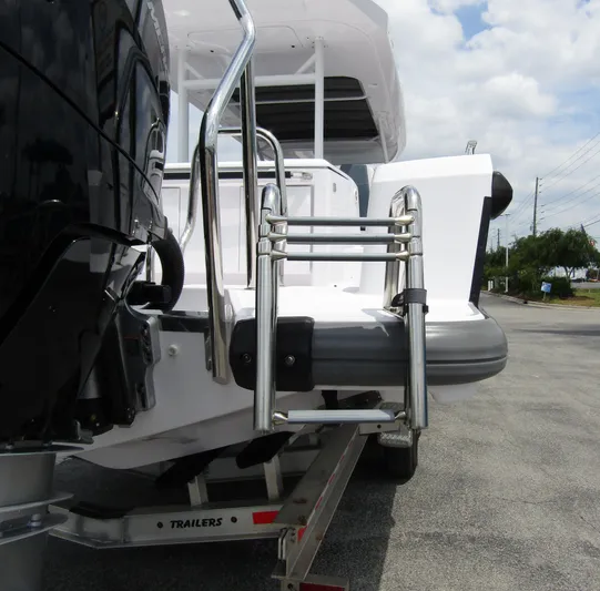  Yacht Photos Pics 2024 Axopar 37 Sun Top boat with stainless steel ladder and outboard motor.