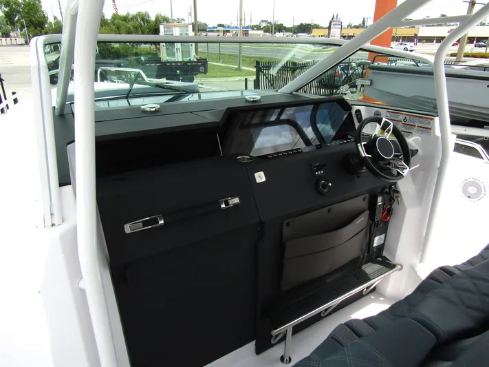  Yacht Photos Pics 2024 Axopar 37 Sun Top boat cockpit with modern steering and dashboard controls.