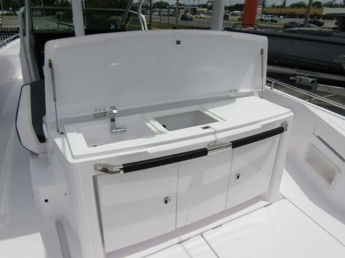  Yacht Photos Pics 2024 Axopar 37 Sun Top boat kitchenette with sink and storage cabinets.