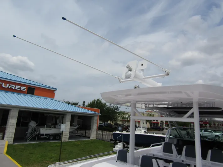  Yacht Photos Pics 2024 Axopar 37 Sun Top boat with radar and antennas, docked near a building.