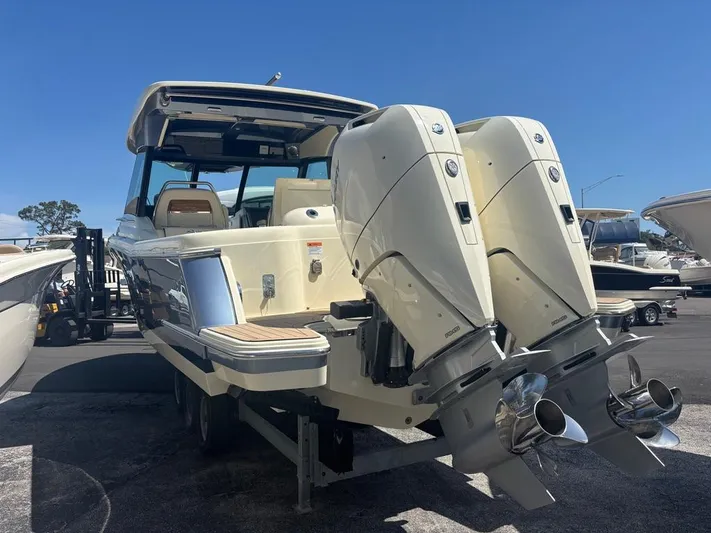  Yacht Photos Pics 2025 Chris-Craft Calypso 32 boat with dual outboard engines, docked under clear blue sky.