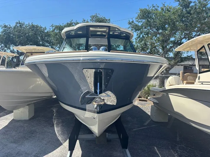  Yacht Photos Pics 2025 Chris-Craft Calypso 32 boat, front view, displayed outdoors with trees in the background.